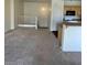 Bright living room featuring neutral carpet, a railing, and an open view into the kitchen at 6316 Beige Bluff St # 201, North Las Vegas, NV 89081