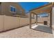 Gravel backyard featuring a covered patio with a concrete slab and a white privacy fence at 6443 Burlap Ct, Las Vegas, NV 89122