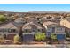 An aerial view showcasing a neighborhood of homes with mountain views in the distance at 6618 Tangled Vines Ave, Las Vegas, NV 89139