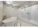 Bright bathroom showcasing soaking tub, walk-in shower with glass doors at 6618 Tangled Vines Ave, Las Vegas, NV 89139