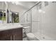 Bright bathroom features a glass shower, marble wall surround and a wood vanity at 6618 Tangled Vines Ave, Las Vegas, NV 89139