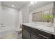 Bright bathroom with a tub-shower, modern vanity, and stylish plant decor at 6618 Tangled Vines Ave, Las Vegas, NV 89139