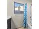 Modern bathroom with a shower-tub combo, window, and stylish blue shower curtain at 6618 Tangled Vines Ave, Las Vegas, NV 89139