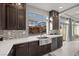 A chef's kitchen showcases ample cabinetry and a sleek farmhouse style sink with backyard views at 6618 Tangled Vines Ave, Las Vegas, NV 89139