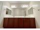 Bathroom featuring double sinks, large mirror, and dark wood cabinets at 6946 Motley Rd, Las Vegas, NV 89178