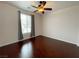 Cozy bedroom with hardwood floors, a ceiling fan, and a large window at 6946 Motley Rd, Las Vegas, NV 89178