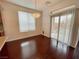 Dining area with a modern chandelier, wood floors, and sliding glass doors to the backyard at 6946 Motley Rd, Las Vegas, NV 89178