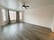 Bright living room with modern gray floors, a ceiling fan, and large windows at 6946 Motley Rd, Las Vegas, NV 89178
