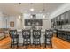 Modern kitchen with black cabinets, granite countertops, stainless steel appliances, and bar seating at 715 Orange Plume Walk, Henderson, NV 89011