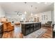 Open-concept living area with a kitchen island, white sectional, and a leather armchair at 715 Orange Plume Walk, Henderson, NV 89011