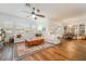 Bright living room featuring a large white sectional sofa, wood floors, ceiling fan, and an adjacent dining area at 715 Orange Plume Walk, Henderson, NV 89011