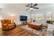 Inviting living room with a leather armchair, white sectional, leather ottomans, and a flat screen television at 715 Orange Plume Walk, Henderson, NV 89011