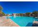 A beautiful pool is surrounded by lounge chairs and trees in this exterior image at 715 Orange Plume Walk, Henderson, NV 89011