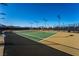 Outdoor tennis courts featuring green and tan court surfaces with black fencing and overhead lighting at 715 Orange Plume Walk, Henderson, NV 89011
