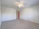 Spacious bedroom with neutral carpet, ceiling fan, and adjacent bathroom doorway at 725 N Royal Crest Cir # 228, Las Vegas, NV 89169