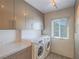 Efficient laundry room featuring built-in cabinets, modern washer, and dryer for added convenience at 725 N Royal Crest Cir # 228, Las Vegas, NV 89169