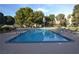 Beautiful outdoor pool with surrounding lounge chairs and mature trees at 725 N Royal Crest Cir # 228, Las Vegas, NV 89169