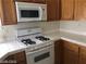 Clean kitchen featuring oak cabinetry and white tile countertops at 75 N Valle Verde Dr # 2121, Henderson, NV 89074
