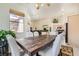 Bright dining room features a wooden table and large window; open floor plan to kitchen at 7515 Splashing Rock Dr, Las Vegas, NV 89131