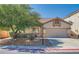 Charming single-story home showcasing a neutral exterior, attached two car garage, well-manicured landscaping, and mature shade trees at 7515 Splashing Rock Dr, Las Vegas, NV 89131