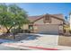 Charming single-story home showcasing a neutral exterior, attached two car garage, well-manicured landscaping, and mature shade trees at 7515 Splashing Rock Dr, Las Vegas, NV 89131