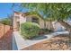 Charming home's front yard with lush green bushes, desert landscape, and private walkway at 7515 Splashing Rock Dr, Las Vegas, NV 89131