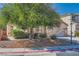 Charming home exterior with desert landscaping, mature tree, and well-maintained front yard at 7515 Splashing Rock Dr, Las Vegas, NV 89131