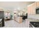 Bright kitchen with granite counters, stainless appliances, an island, and a view of the dining and living areas at 7515 Splashing Rock Dr, Las Vegas, NV 89131