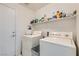 Clean laundry room with appliances and ample shelving for storage at 7515 Splashing Rock Dr, Las Vegas, NV 89131