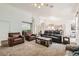 Bright and airy living room featuring a vaulted ceiling, comfortable seating, and a view to kitchen at 7515 Splashing Rock Dr, Las Vegas, NV 89131