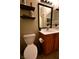 Features a toilet with a wood cabinet vanity and decorative shelves at 7727 Widewing Dr, North Las Vegas, NV 89084