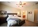 Bedroom featuring a ceiling fan, a bed with patterned comforter, and an en-suite bathroom at 7727 Widewing Dr, North Las Vegas, NV 89084