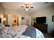 Bedroom displaying a ceiling fan, a dresser with a television, and an en-suite bathroom at 7727 Widewing Dr, North Las Vegas, NV 89084