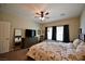 Bedroom showcasing a ceiling fan, a dresser with a television, and a bed with a patterned comforter at 7727 Widewing Dr, North Las Vegas, NV 89084