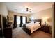 Bedroom with black-out curtains, ceiling fan, and bed with patterned comforter at 7727 Widewing Dr, North Las Vegas, NV 89084