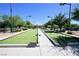 Outdoor bocce ball court featuring artificial turf, perimeter benches, and overhead lighting for evening play at 7727 Widewing Dr, North Las Vegas, NV 89084