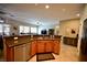 Features a stainless steel dishwasher and a granite countertop with medium toned wood cabinets at 7727 Widewing Dr, North Las Vegas, NV 89084