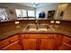 Close-up view of a modern kitchen sink with granite countertops and wood cabinetry at 7727 Widewing Dr, North Las Vegas, NV 89084