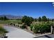 Beautifully landscaped view overlooking a golf course with desert plants, trees, and distant mountains under a clear sky at 7727 Widewing Dr, North Las Vegas, NV 89084