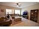 Open living room with a large sofa, ceiling fan, and large bright windows at 7727 Widewing Dr, North Las Vegas, NV 89084