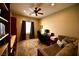 This room has built in shelving, a window, a ceiling fan, a desk with computer, and a sofa at 7727 Widewing Dr, North Las Vegas, NV 89084