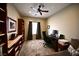 This room has built in shelving, a window, a ceiling fan, a desk with computer, and a sofa at 7727 Widewing Dr, North Las Vegas, NV 89084