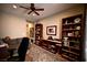 Cozy home office with custom built in shelving, ceiling fan, and neutral decor at 7727 Widewing Dr, North Las Vegas, NV 89084