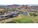 Aerial view of a golf course community featuring lush greens, a clubhouse, tennis courts, and mountain views at 8 Via Tiberina, Las Vegas, NV 89011