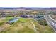 Aerial view of a golf course community showcasing lush greens, a clubhouse, and tennis courts with picturesque mountain views at 8 Via Tiberina, Las Vegas, NV 89011