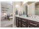 Bathroom featuring a dual sink vanity, dark cabinets, neutral paint, with view into bedroom at 8 Via Tiberina, Las Vegas, NV 89011