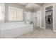 Modern bathroom featuring a soaking tub, glass shower, and a large window bringing in natural light at 8 Via Tiberina, Las Vegas, NV 89011