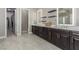 Bathroom with a double sink vanity, tile floors, modern lighting, and a doorway leading to a walk-in closet at 8 Via Tiberina, Las Vegas, NV 89011
