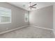 Empty bedroom with neutral paint, carpet, ceiling fan, and bright light from two windows at 8 Via Tiberina, Las Vegas, NV 89011