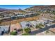 An elevated view showcasing houses in a desert community with well-kept landscaping and views of the surrounding mountains at 8 Via Tiberina, Las Vegas, NV 89011